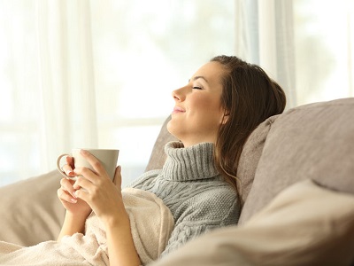 Woman relaxing at home holding a coffee mug