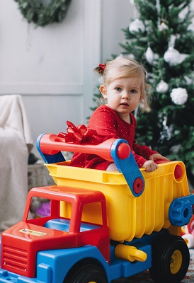 child in big toy truck on Christmas morning