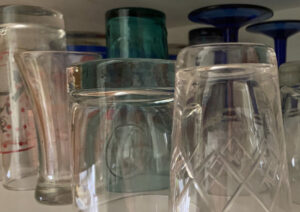 Glasses cluttered in kitchen cupboard