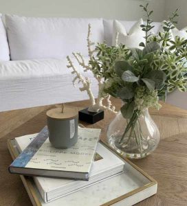Light open living area with vase and books on table