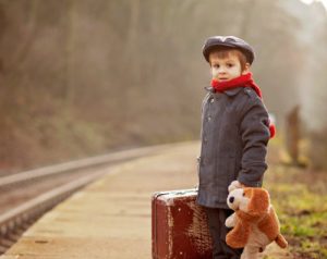 young boy with suitcase at station